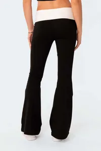 Back view of fashionable slim fit black flare yoga pants with white fold-over waistband