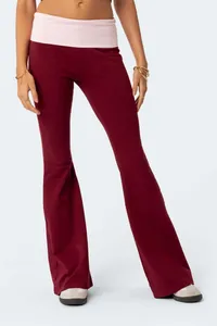 Close-up of slim-fit burgundy flare pants with a pink fold-over waistband