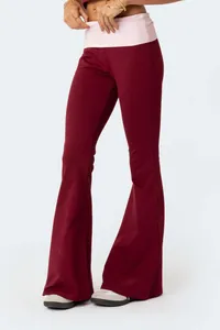 Fashionable maroon flare yoga pants featuring a pink fold-over waistband and slim fit
