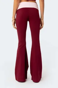 Detail view of wine red flared yoga pants with a contrasting pink low-waist band.