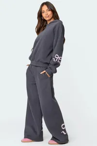 Full view of the grey oversized hoodie set showing pink ribbon details on the side
