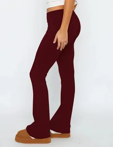 A detailed side view of burgundy low-waisted flare pants featuring a fold-over waistband