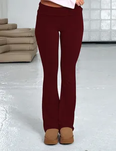 Detailed view of women's slim fit burgundy flare pants with low fold-over waist design