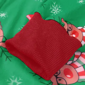 Close-up of red ribbed cuff on green Christmas jumpsuit with reindeer and snowflake prints
