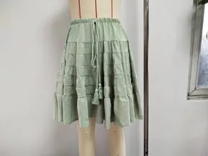 Close-up detail of high-waist light green tiered mini skirt with drawstring tassel
