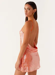 Back view of a shimmering peach sequined mini dress featuring a low back design
