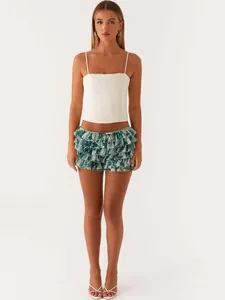 Trendy multi-layer ruffled floral mini skirt shown on a model with a white top