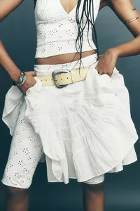 Detail view of a white tiered ruffle cake skirt with intricate eyelet lace texture.