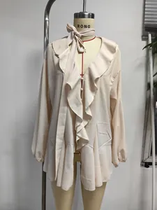 Elegante camicetta in chiffon beige con volant e collo con fiocco su un manichino
