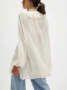Vista posteriore dettagliata di una blusa in chiffon crema con eleganti ruches al collo
