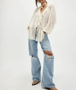 Elegante camicia in chiffon bianco con ruches, scollo a V e maniche a campana nel dettaglio