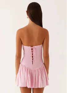 Back view detail of a pink strapless mini dress featuring a corset lace-up closure.