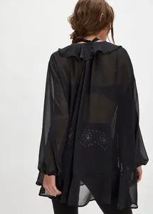 Vista posteriore di una camicetta di chiffon nero trasparente con volant e borchie