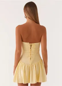 Back view detail of yellow strapless mini dress with elegant lace-up corset design