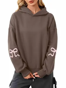 Women's oversized brown hoodie with pink bow graphics on sleeves for autumn