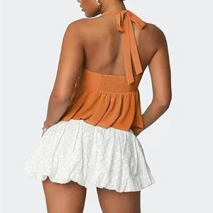 Πίσω όψη ενός πορτοκαλί σιφόν halter top με λευκή φούστα με κέντημα για γυναίκες