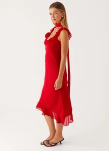 Side profile of a vibrant red sleeveless midi dress with ruffled details and leg slit