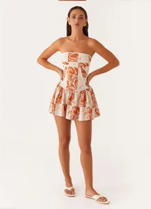 Detailed view of strapless floral print mini dress on model against plain background