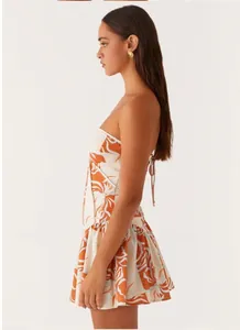 Side profile showing a floral bandeau backless mini dress with elegant tie-up back details.