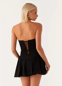 Detailed back view of a black strapless mini dress with lace-up corset design.