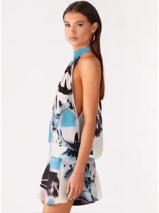 Close-up side view of a summer sleeveless halter backless mini dress with abstract blue print
