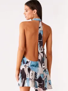 Back view of sexy halter neck dress with abstract print and open back detail.