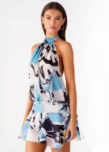 A professional model showcasing a blue and white abstract print halter neck backless mini dress