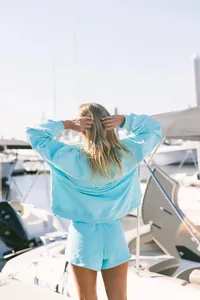 Vista trasera de una mujer con un conjunto de sudadera y pantalones cortos azul claro
