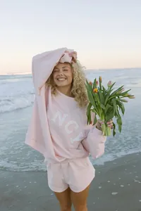 Detalle de conjunto de sudadera y pantalón corto rosa para mujer con letras FANCY.
