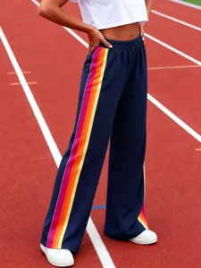 Fashionable navy blue wide-leg joggers with vibrant rainbow side stripes on a track