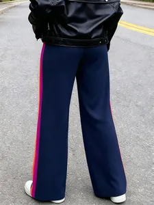 Back view of navy blue wide-leg trousers with vibrant pink and orange side stripes