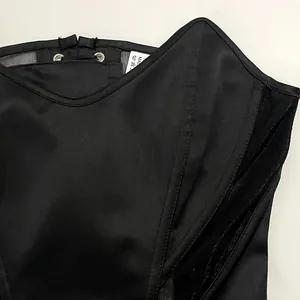 Detailaufnahme eines schwarzen Korsett-Tops mit Satin- und Mesh-Patchwork-Struktur
