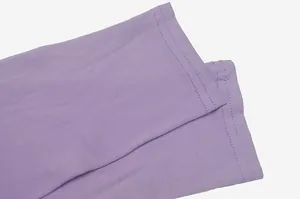 Detailed close-up of the double-stitched cuffs on a purple long-sleeved pleated dress.