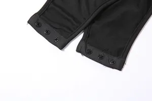 Détail de la fermeture par boutons-pression métalliques d'un body noir ajusté
