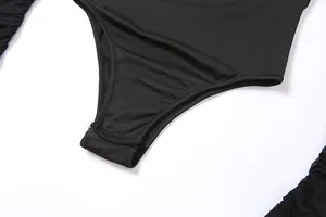 Vue rapprochée détaillée de la fermeture par boutons-pression au bas de ce body noir
