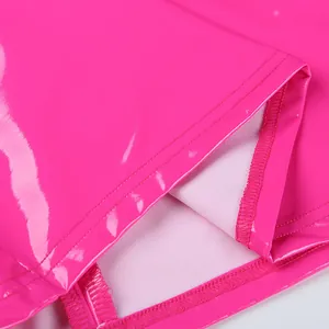 Close-up detail of high-shine pink PU leather dress showing hemline stitching and fabric texture