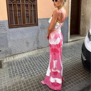 Detailaufnahme eines stilvollen Maxikleides mit rosa Blumendruck in sommerlicher Umgebung