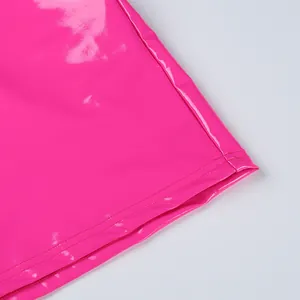 Macro detail of the bright pink shiny PU leather garment hem with professional stitching