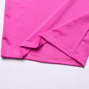 Primo piano delle cuciture pulite a doppio ago sull'orlo di un vestito rosa vibrante.