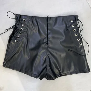 Gros plan sur un short taille haute en simili cuir noir avec laçage sur les côtés