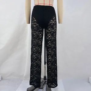 Detail of sexy black floral lace see-through high-waisted straight-leg trousers for women.