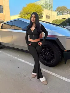 Chic black two-piece set featuring a zip-up hoodie and high-waisted flare pants for women