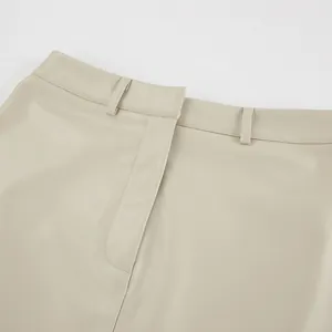 Detailed view of high-waisted beige PU leather skirt waistband showing belt loops