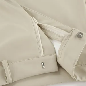 Close-up of the hidden zipper and metal clasp on a beige PU leather high-waisted skirt