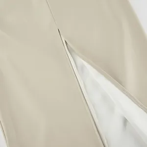 Close-up of a high-waisted beige PU leather skirt featuring a stylish back slit detail.