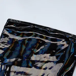 Nahaufnahme des glänzenden schwarzen Metallic-Stoffs und der oberen Naht eines Kleides.