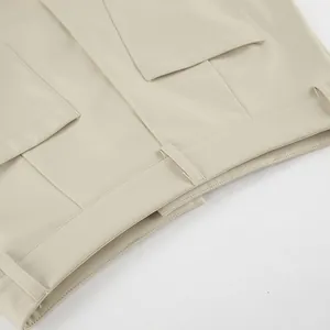 Detail view of beige high-waisted PU leather skirt with belt loops and pocket stitching