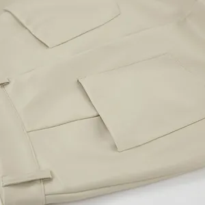 Close-up of beige PU leather skirt detail showing back pocket and waist stitching.