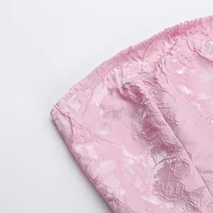 Κοντινό πλάνο ροζ ζακάρ υφάσματος με floral σχέδιο και ραφές σε στράπλες φόρεμα