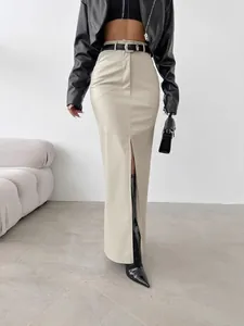 Fashionable high-waist beige PU leather maxi skirt with front slit and black belt.